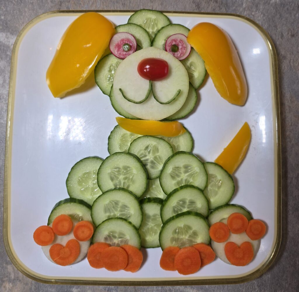 Gemüseplatte für Kinder als Hund aus Gurken, Kohlrabi und Tomaten